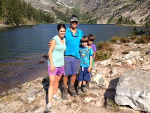 Family smiling on rock lake in lower Clark Fork watershed